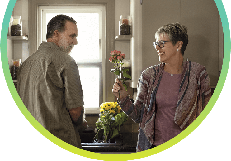 A woman giving a red flower to a man.