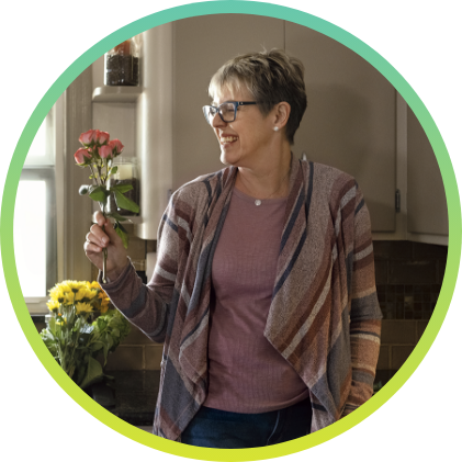 A woman holding a red flower.